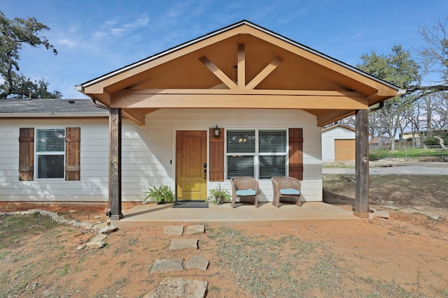 view of front of home with an outbuilding, a porch, and a garage