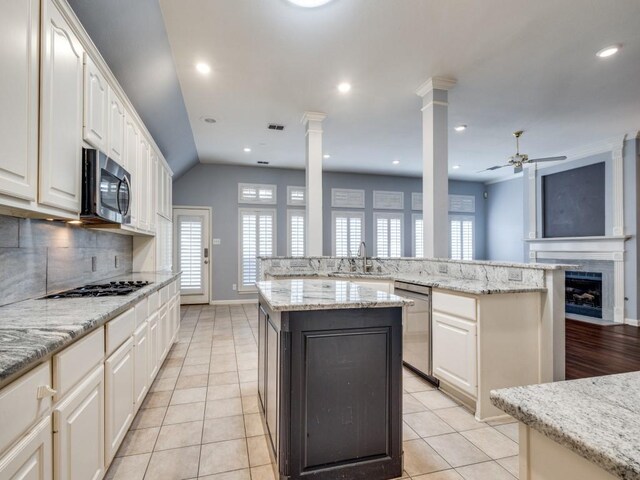 kitchen with light stone countertops, sink, a kitchen island, and appliances with stainless steel finishes