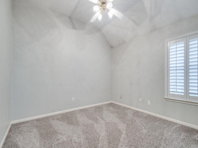 carpeted empty room with ceiling fan, lofted ceiling, and a wealth of natural light