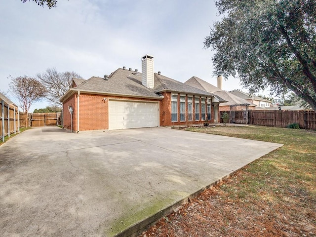 back of property with a yard and a garage