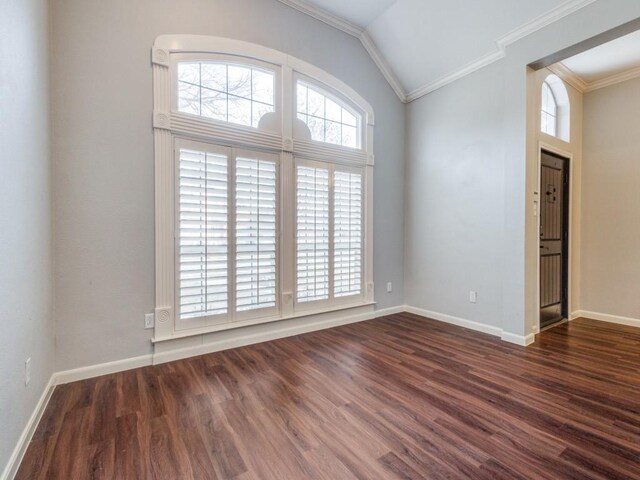 empty room with lofted ceiling, dark hardwood / wood-style floors, and ornamental molding