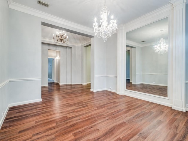 unfurnished dining area featuring hardwood / wood-style flooring, crown molding, and a chandelier