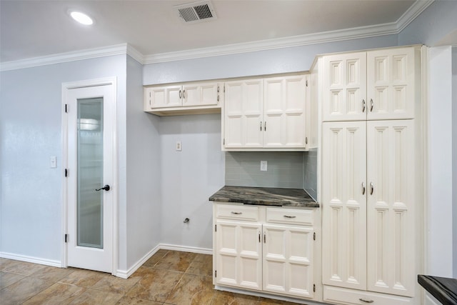 kitchen with tasteful backsplash, crown molding, and white cabinets