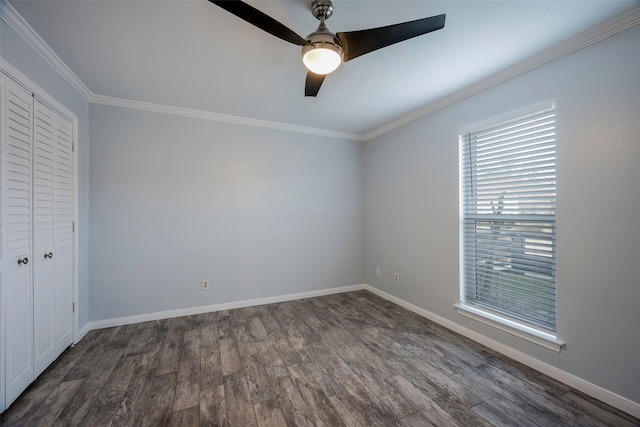 unfurnished bedroom featuring dark hardwood / wood-style flooring, ornamental molding, a closet, and ceiling fan