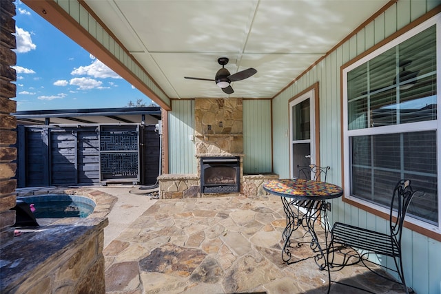 view of patio featuring ceiling fan and an outdoor stone fireplace