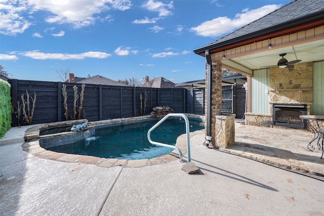 view of pool featuring ceiling fan, a patio area, pool water feature, and an outdoor stone fireplace