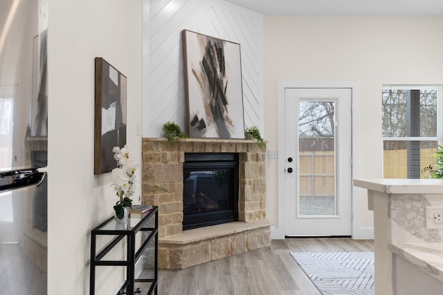 foyer entrance featuring a fireplace and light wood-type flooring