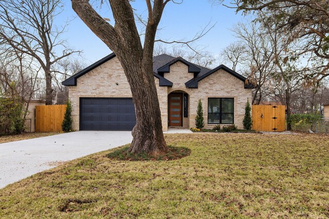 french country style house featuring a front yard and a garage