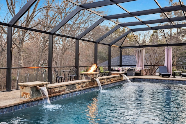 view of pool featuring pool water feature, a lanai, an outdoor fire pit, and a patio