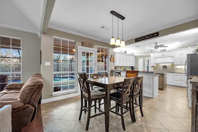 tiled dining space featuring a wealth of natural light, ceiling fan, and ornamental molding