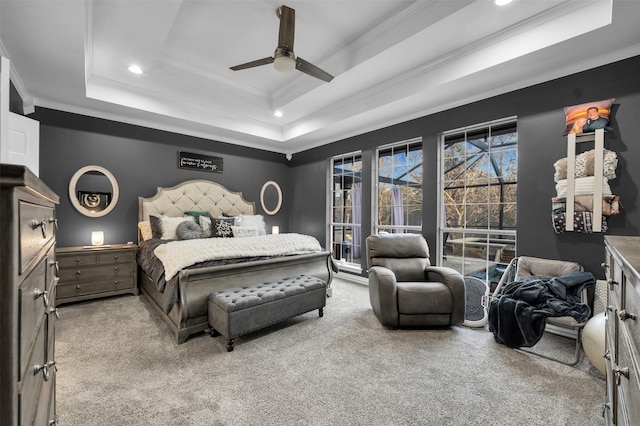 bedroom with ceiling fan, a raised ceiling, light colored carpet, and ornamental molding