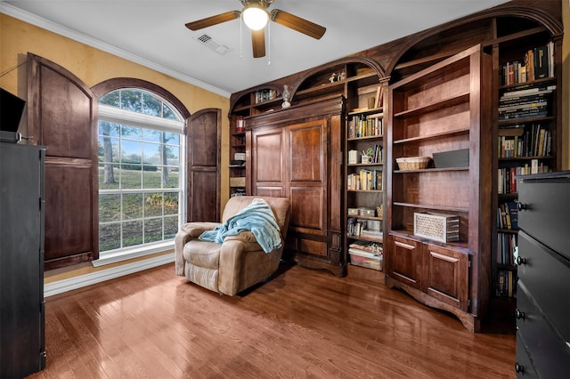 sitting room featuring ceiling fan, plenty of natural light, hardwood / wood-style floors, and built in features