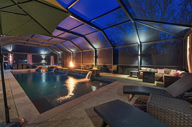 pool at night featuring a jacuzzi, pool water feature, an outdoor living space, and a patio