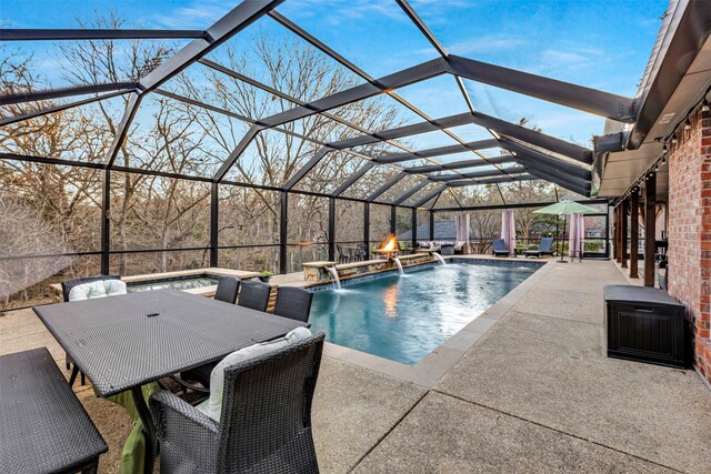 view of pool featuring a lanai, a patio area, pool water feature, and a jacuzzi