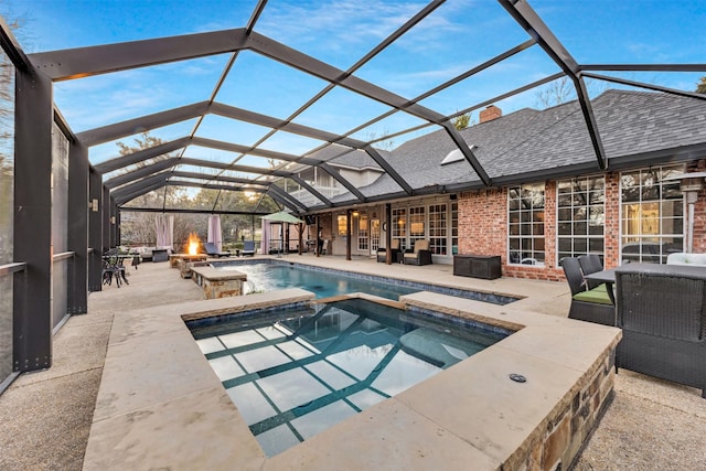 view of swimming pool with a lanai, an in ground hot tub, an outdoor living space with a fire pit, and a patio