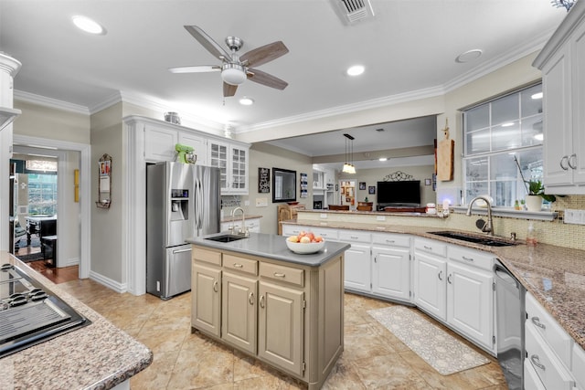 kitchen with sink, hanging light fixtures, a kitchen island, white cabinets, and appliances with stainless steel finishes