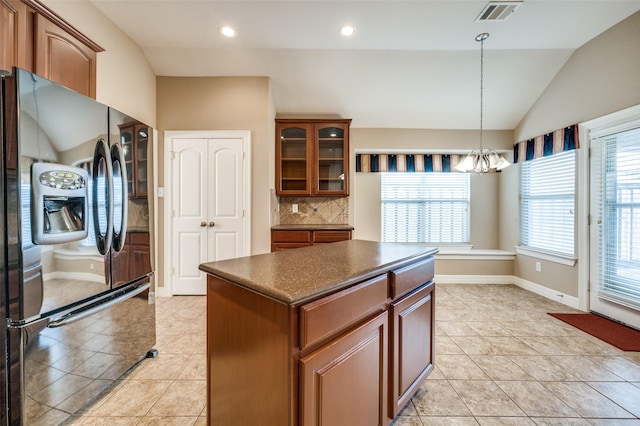 kitchen with refrigerator with ice dispenser, vaulted ceiling, hanging light fixtures, backsplash, and a center island