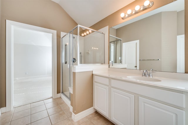 bathroom with vaulted ceiling, tile patterned flooring, a shower with shower door, and vanity