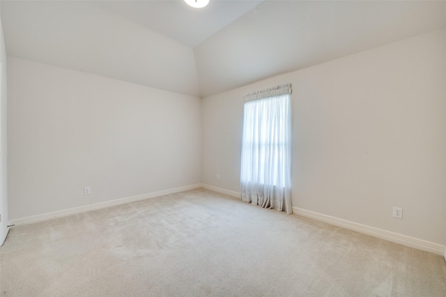 carpeted spare room with lofted ceiling