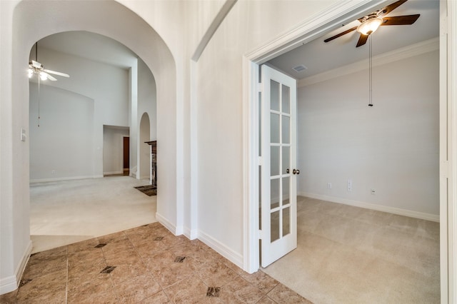 corridor with crown molding and light colored carpet