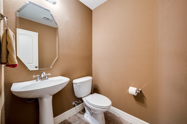 bathroom with toilet and tile patterned flooring