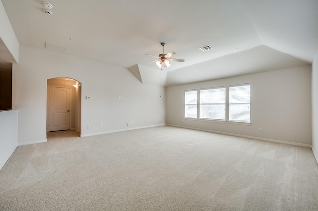 spare room with light carpet, vaulted ceiling, and ceiling fan