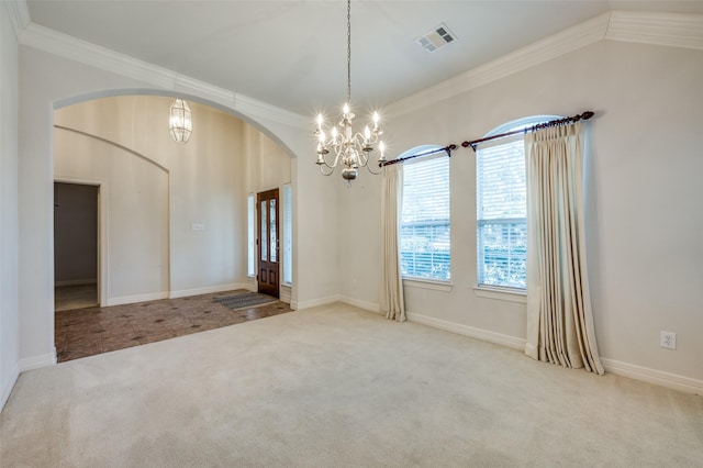 empty room featuring carpet, ornamental molding, and an inviting chandelier