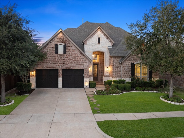 french country style house featuring a yard and a garage