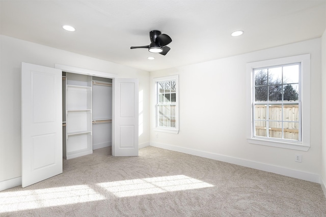 unfurnished bedroom featuring ceiling fan, a closet, and light carpet