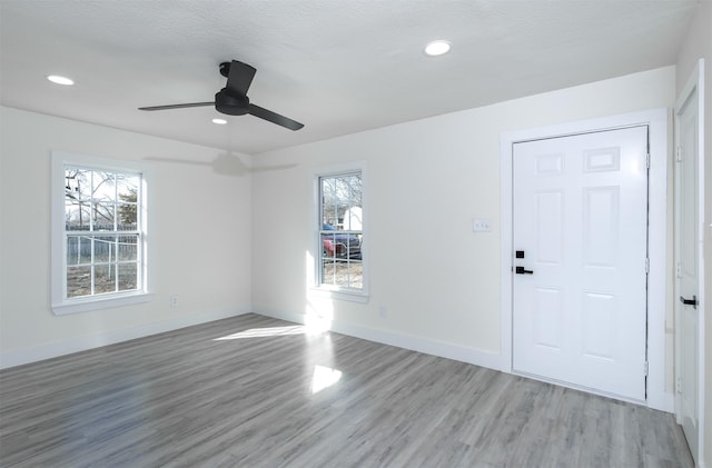 foyer entrance featuring ceiling fan, light hardwood / wood-style flooring, and a healthy amount of sunlight