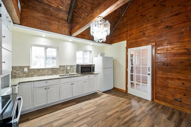 kitchen featuring stainless steel appliances, hanging light fixtures, sink, and white cabinets