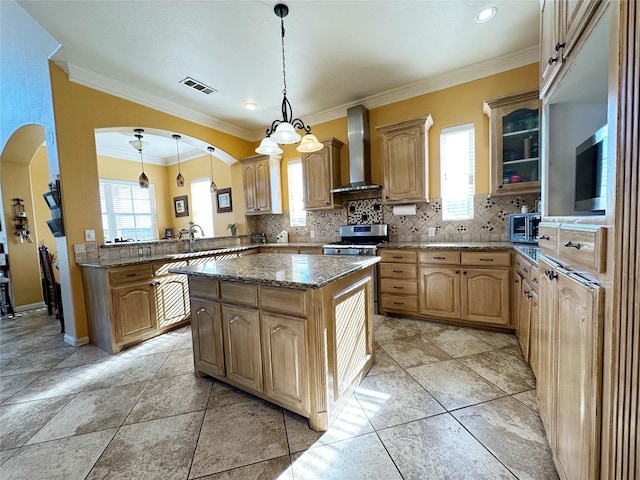 kitchen featuring pendant lighting, a center island, wall chimney range hood, kitchen peninsula, and a chandelier