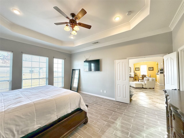 bedroom featuring a tray ceiling, ornamental molding, light hardwood / wood-style floors, and ceiling fan