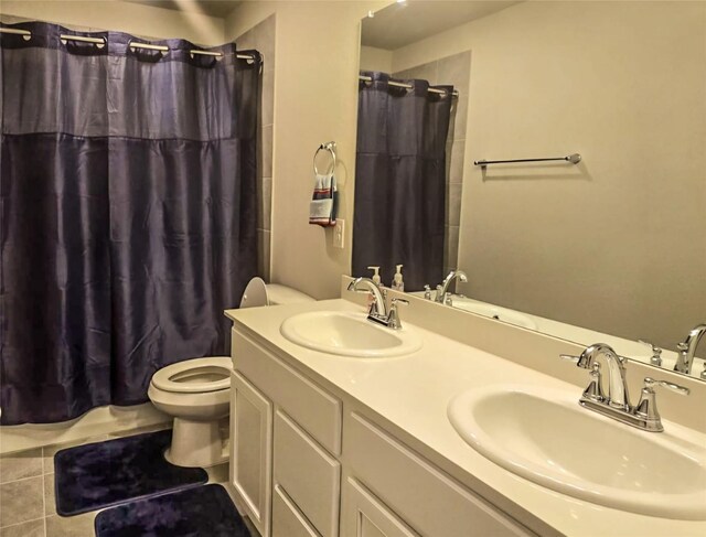 bathroom featuring toilet, vanity, tile patterned floors, and walk in shower