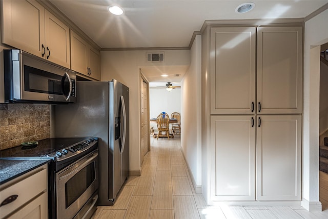 kitchen with decorative backsplash, stainless steel appliances, ceiling fan, dark stone countertops, and gray cabinets