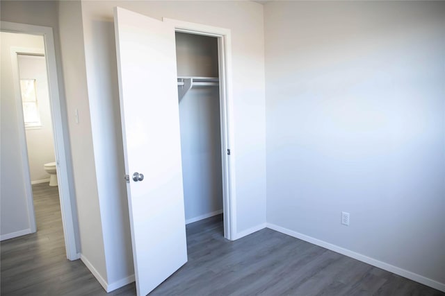 unfurnished bedroom with a closet and dark hardwood / wood-style floors