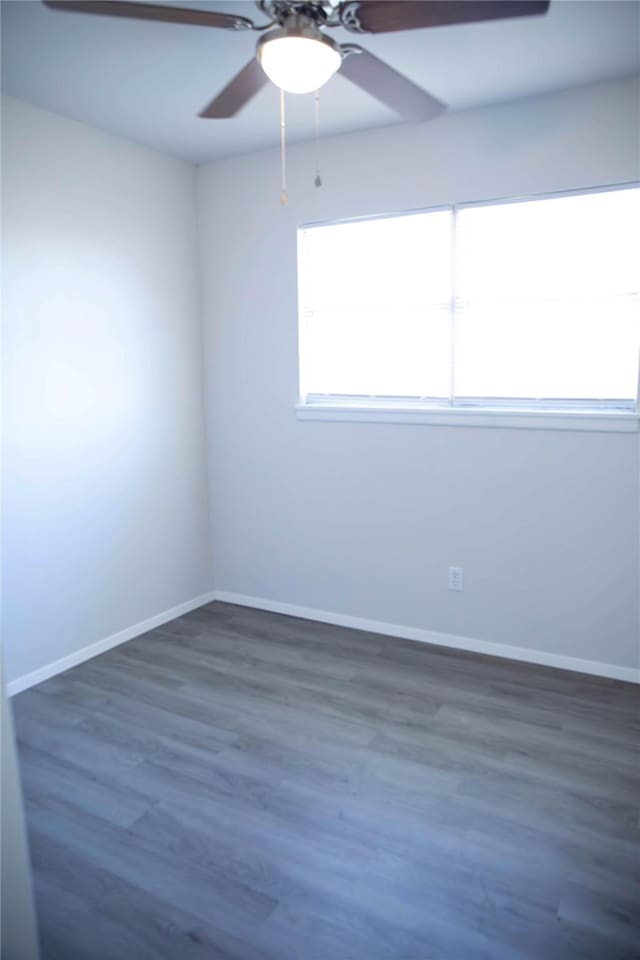 empty room with dark wood-type flooring and ceiling fan