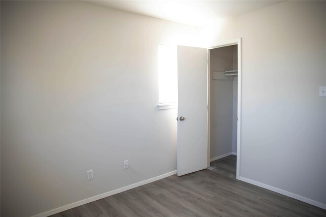 unfurnished bedroom featuring dark wood-type flooring and a closet