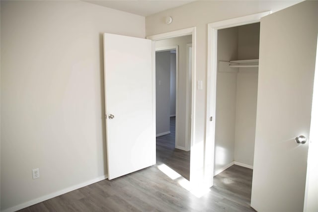 unfurnished bedroom featuring wood-type flooring and a closet