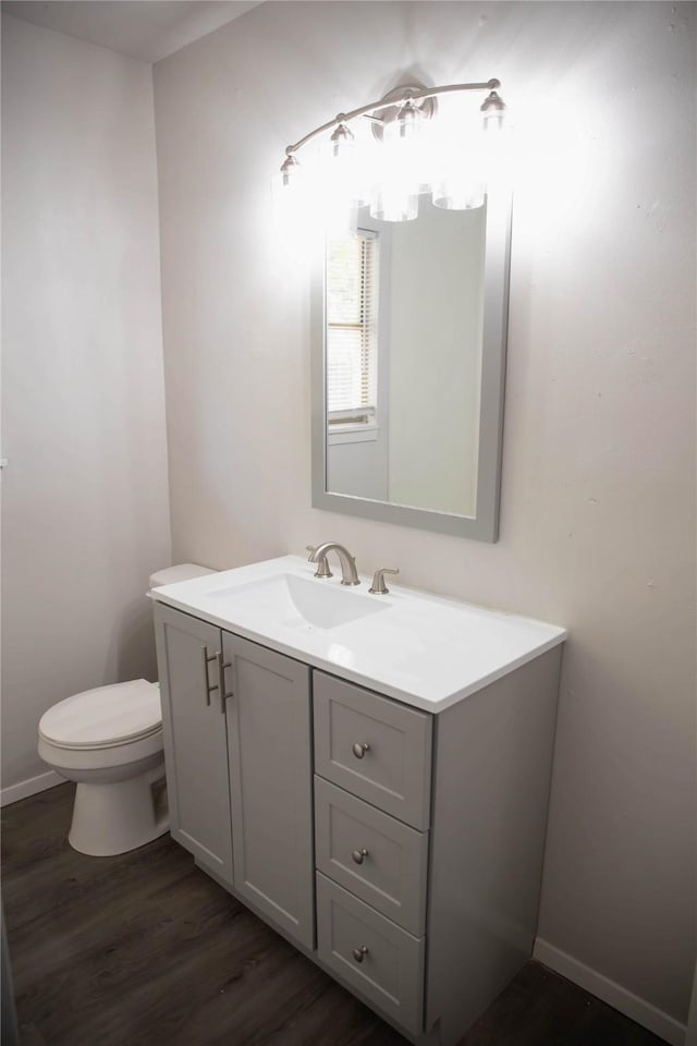 bathroom with vanity, wood-type flooring, and toilet