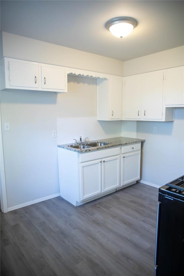 kitchen featuring white cabinetry, black range oven, dark hardwood / wood-style floors, and sink