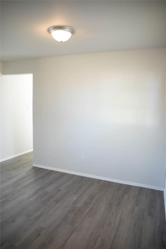 empty room with dark hardwood / wood-style flooring