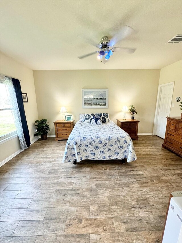 bedroom with ceiling fan, vaulted ceiling, and light wood-type flooring