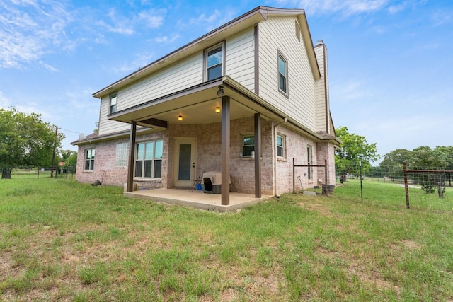 rear view of property with a lawn and a patio