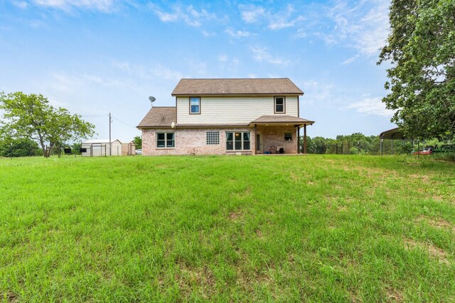 rear view of house featuring a carport and a yard