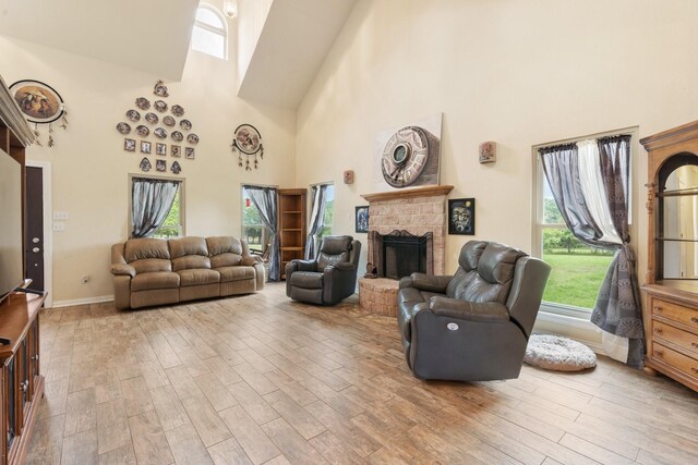 living room featuring plenty of natural light, light hardwood / wood-style floors, and a high ceiling