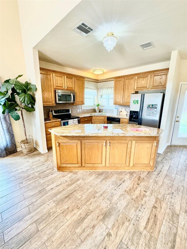 kitchen featuring light stone countertops, appliances with stainless steel finishes, backsplash, sink, and light tile patterned flooring