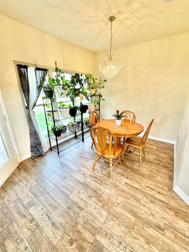 dining area with a chandelier and light hardwood / wood-style flooring