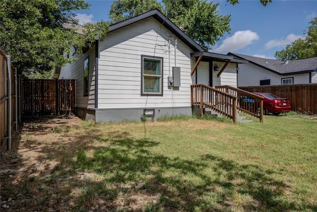 rear view of property featuring a lawn