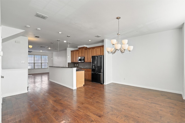 kitchen featuring decorative backsplash, an inviting chandelier, decorative light fixtures, and black fridge